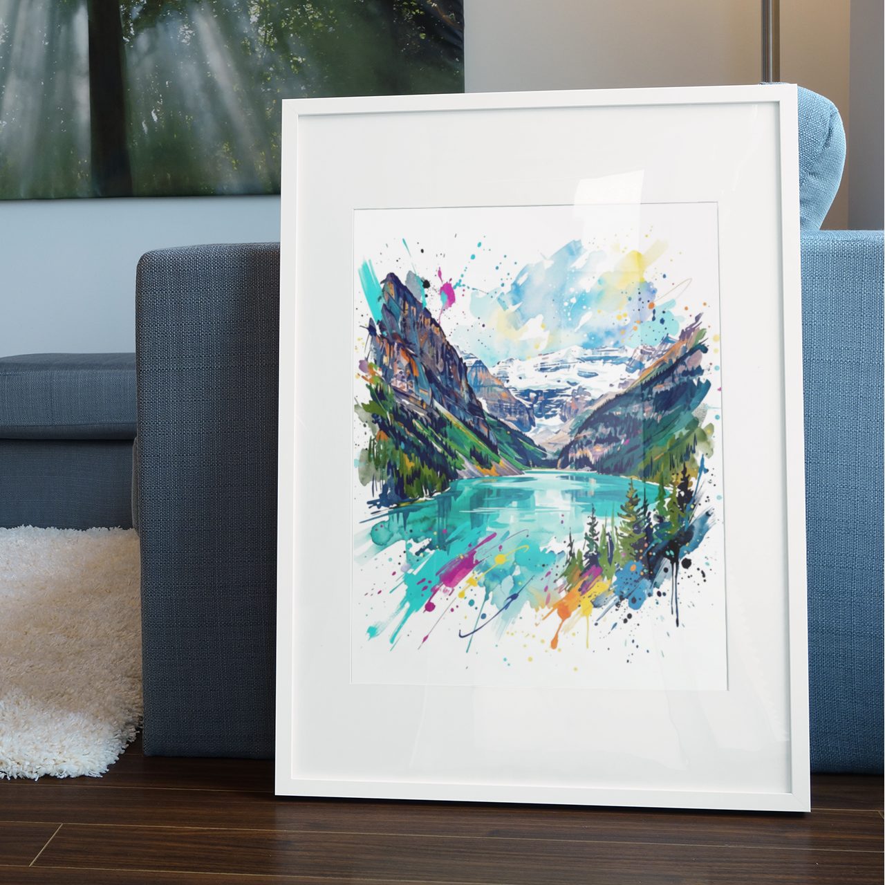 A framed watercolor art print depicting a colourful Lake Louise landscape, leaning against a gray sofa in a modern living room setting.