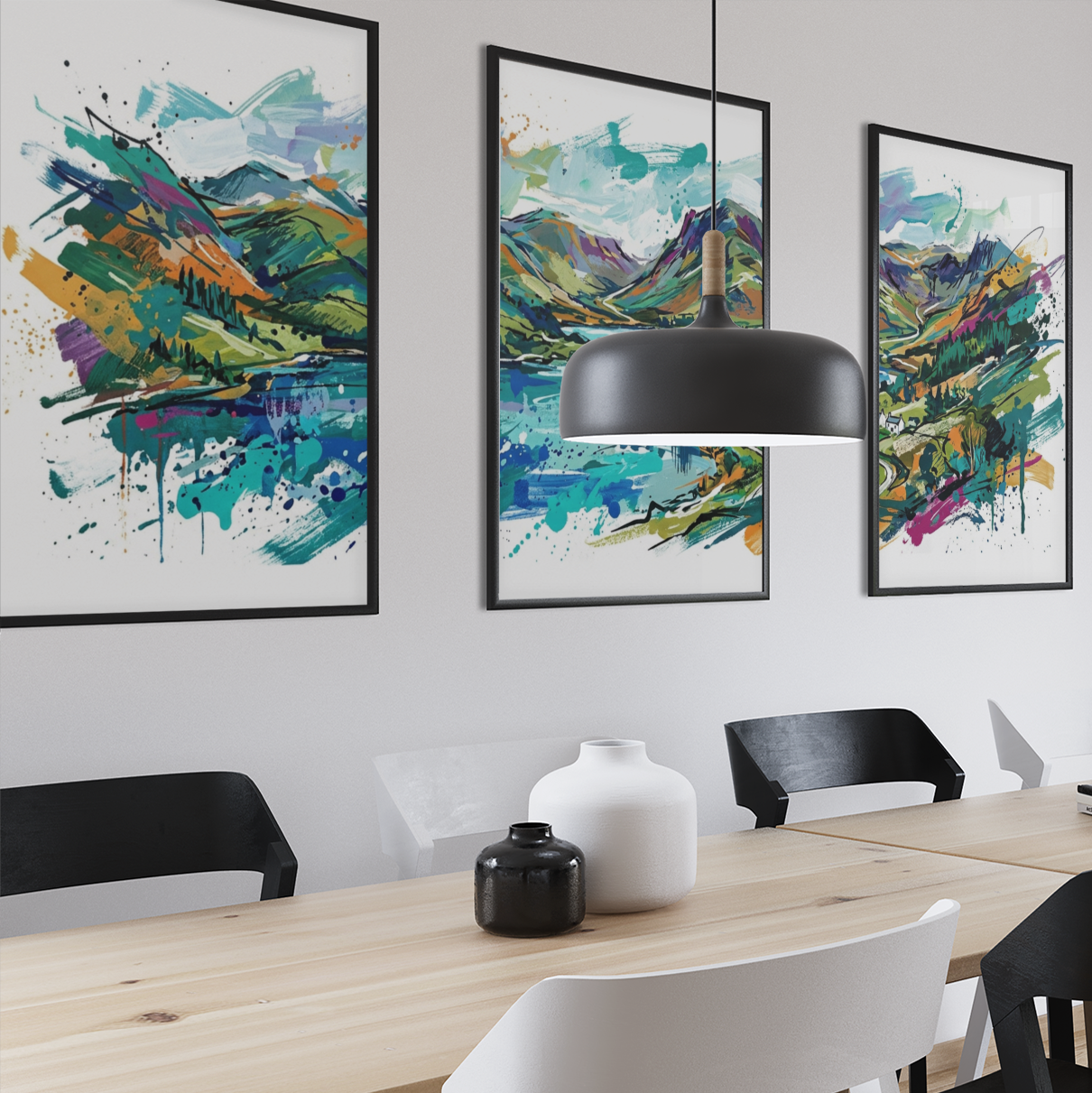 Three framed abstract landscape paintings in vibrant green, blue, and yellow tones hang on a white wall above a light wood dining table with black and white chairs in a modern dining room setting.